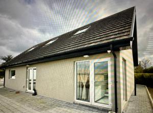 un pequeño edificio blanco con techo negro en Country Haven Comfy & Sleek House, en Monasterevin