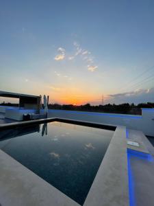- une piscine sur le toit d'une maison au coucher du soleil dans l'établissement Pandora B&B, à Porto Cesareo