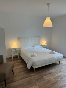 a bedroom with a large white bed and two tables at Smart Living Swiss in Chiasso