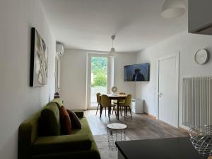 un soggiorno con divano verde e tavolo di Smart Living Swiss a Chiasso