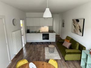 a living room with a green couch and a kitchen at Smart Living Swiss in Chiasso