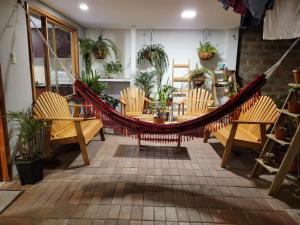 a hammock in a patio with chairs and a table at Maria minidepartamento Loja in Loja