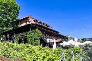 a building with a restaurant with tables and umbrellas at Gościniec Ryński Młyn in Ryn