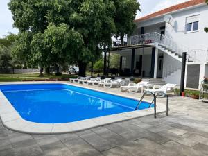 a swimming pool in front of a house at Apartment 877-1 in Bibinje