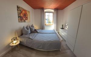 um quarto com uma cama e uma janela em Ferienwohnung Frauenmarkt em Schneeberg