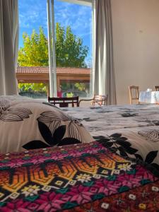 a bedroom with two beds and a large window at El Nido in Ciudad Lujan de Cuyo