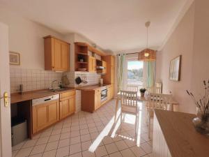 a kitchen with wooden cabinets and a table and chairs at Appartementhaus Plueckhahn in Kühlungsborn