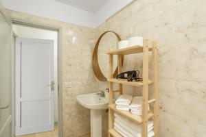 a bathroom with a sink and a shelf with towels at Vv Isla Bonita- C - 84 in Los Cancajos +17 photos