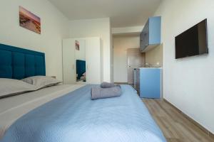a bedroom with a large bed with a television on the wall at DERON Apartments in Ulcinj