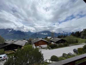 Blick auf ein Dorf mit Bergen im Hintergrund in der Unterkunft Chalet rose des vents in Crans-Montana