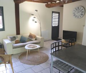 a living room with a couch and a table at La Grange du Tôt in Fontenay