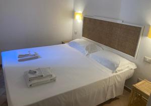 a white bed with two towels on top of it at Casa Per 4 in Porto Santo Stefano