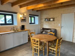 eine Küche und ein Esszimmer mit einem Holztisch und Stühlen in der Unterkunft Gîte du Redondet 