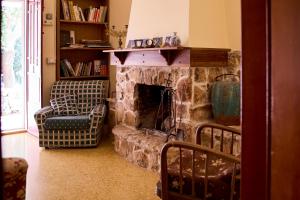 sala de estar con chimenea de piedra y silla en Agriturismo Teatro del grano, en Alberobello