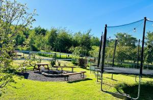 un parco con tavoli da picnic e panchine in erba di Apartament Sweet Time a Huta Szklana