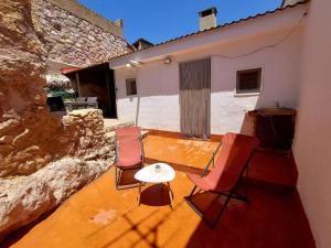 patio z krzesłami i stołem oraz budynek w obiekcie Casa rural con barbacoa y amplia terraza. w mieście Jorquera