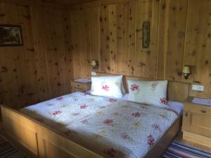 1 dormitorio con 1 cama con paredes de madera en Lanzer Obheimat, en Außervillgraten