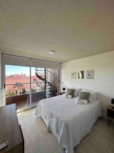 Giường trong phòng chung tại Departamento con vista panorámica frente a termas