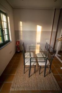 a dining room with a glass table and two chairs at Casa con finca cerca de playas in Valdoviño