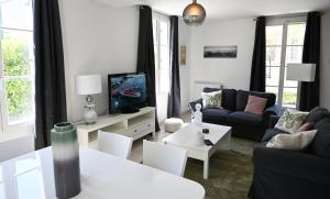 ein Wohnzimmer mit einem Sofa und einem TV in der Unterkunft Disneyland Paris Modern Villa in Bailly-Romainvilliers