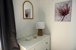 eine weiße Kommode mit Lampe und Spiegel in der Unterkunft Disneyland Paris Modern Villa in Bailly-Romainvilliers + 21 Fotos