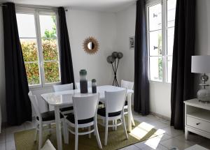 ein Esszimmer mit einem weißen Tisch und Stühlen in der Unterkunft Disneyland Paris Modern Villa in Bailly-Romainvilliers