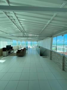 a large room with white tile floors and windows at CASA COM PISCINA À BEIRA MAR. in Recife