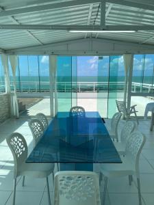 a dining room with a blue table and chairs at CASA COM PISCINA À BEIRA MAR. in Recife
