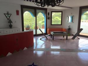 a living room with an orange couch and a table at Anima Rooms & Pool in San Pasquale