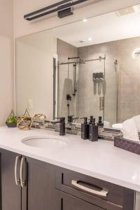 uma casa de banho com um lavatório e um espelho grande em River Oasis, Khlozy Escape the Ordinary em Cornwall