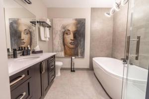 a bathroom with a painting of two women on the wall at River Oasis, Khlozy Escape the Ordinary in Cornwall