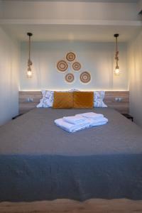 a bedroom with a large bed with two towels on it at Olea Apartments Palioura Epanomi in Epanomi