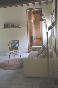 un soggiorno con divano e sedia di La Grange du Tôt a Fontenay