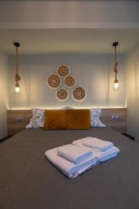 a bedroom with a bed with two towels on it at Olea Apartments Palioura Epanomi in Epanomi