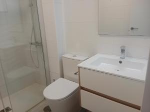 ein Badezimmer mit Toilette, Waschbecken und Dusche in der Unterkunft Las Olas Blue in Playa del Ingles + 14 Fotos