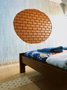 Ce lit se trouve dans une chambre dotée d'un mur en briques. dans l'établissement Vineyard Retreat Voi, à Voi