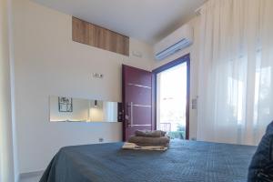 a bedroom with a bed with a blue blanket on it at Olea Apartments Palioura Epanomi in Epanomi
