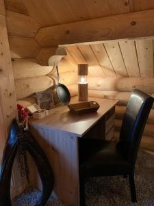 einen Schreibtisch mit einer Lampe und einem Stuhl in einem Zimmer in der Unterkunft Hahnenkleer Hütte in Goslar