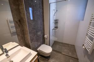 e bagno con doccia, servizi igienici e lavandino. di Belgrade Waterfront Residences - Beograd na vodi a Belgrado