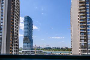 a view of a skyscraper between two buildings at Belgrade Waterfront Residences - Beograd na vodi in Belgrade