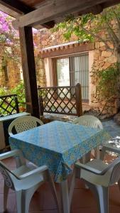 un tavolo e sedie sul portico di una casa di Rotondo Residence - Simar Vacanze a Porto Rotondo