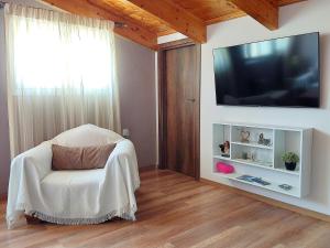 ein Wohnzimmer mit einem Stuhl und einem Flachbild-TV in der Unterkunft Travelers Stasis Nafpaktos in Nafpaktos