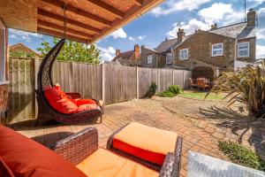 a patio with a hammock and a fence at Langleys Cottage in Heacham