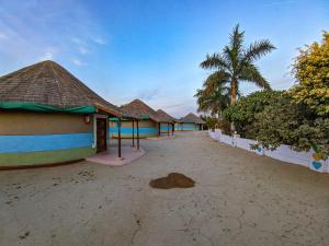 una fila de casas en una playa con palmeras en Desert King Resort en Dhordo