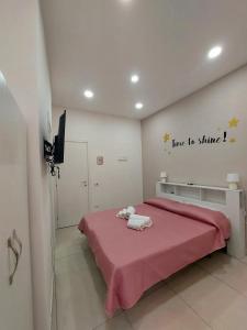 1 dormitorio con 1 cama con manta rosa en NapoliDream Bed and Breakfast, en Nápoles