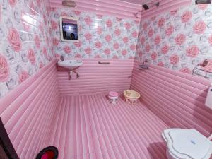 a pink room with a toilet and a sink at Desert King Resort in Dhordo