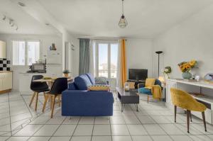 een woonkamer met een blauwe bank en stoelen bij Le Clos des Rosiers in Toulouse