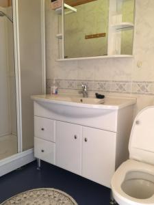 a bathroom with a white sink and a toilet at Sjøstrand Rorbuer v Børge Iversen AS in Ballstad