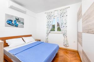 a bedroom with a blue bed and a window at Villa Laura in Vantačići +40 photos