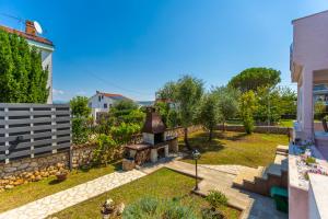 a backyard with a stone wall and a grill at Villa Laura in Vantačići